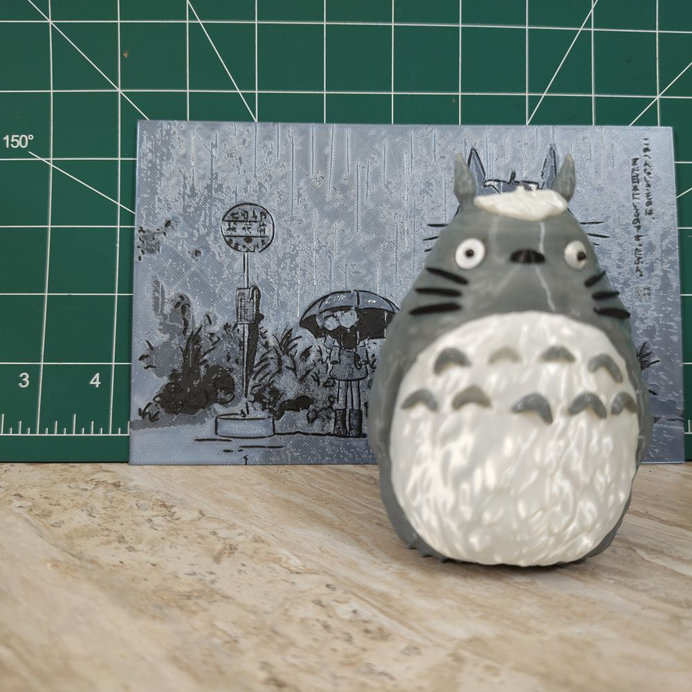 A photo lithophane panel printed in grey PLA, displayed beside a figurine
