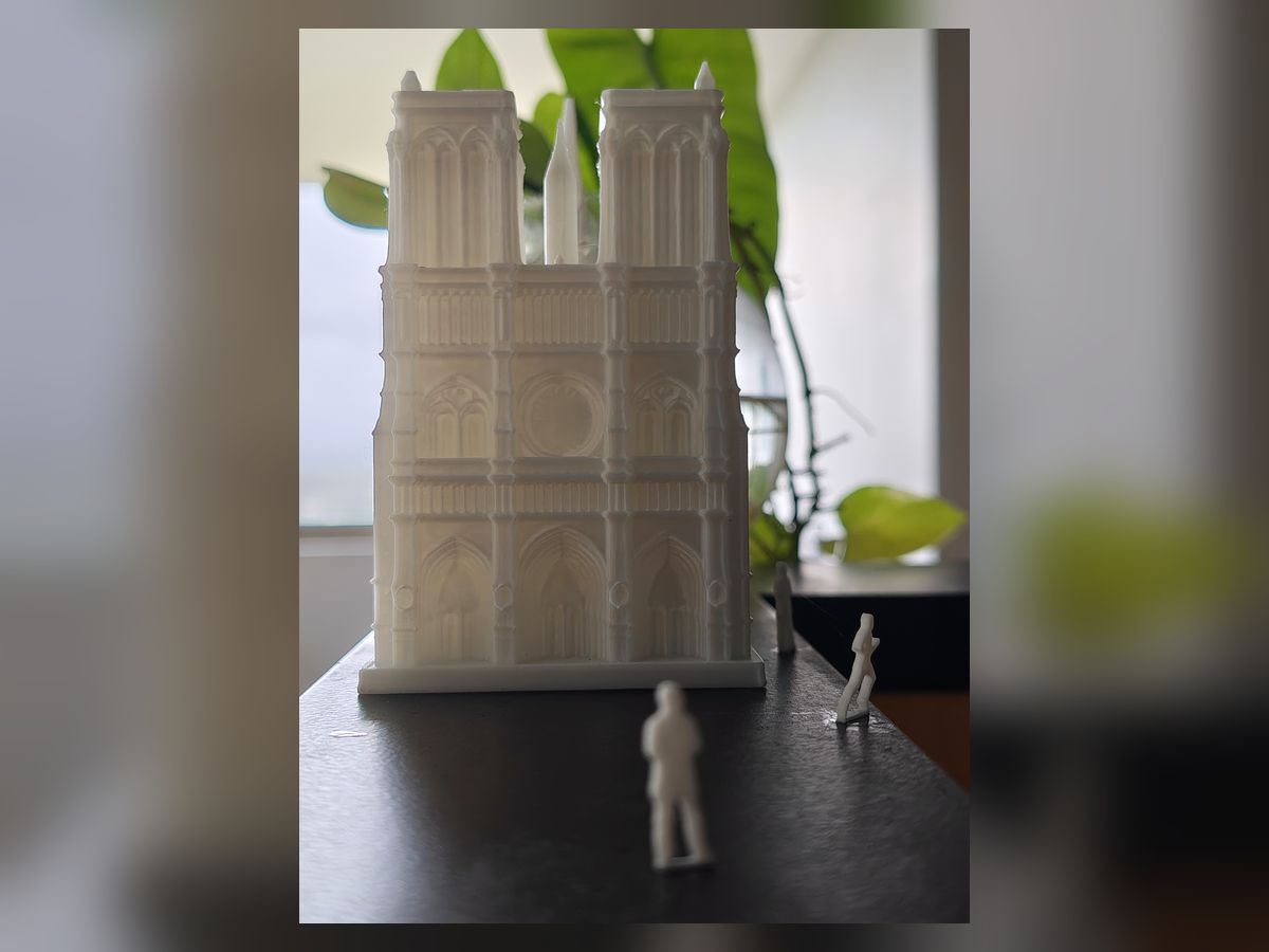 A grey scale model of Notre-Dame de Paris with figures for scale