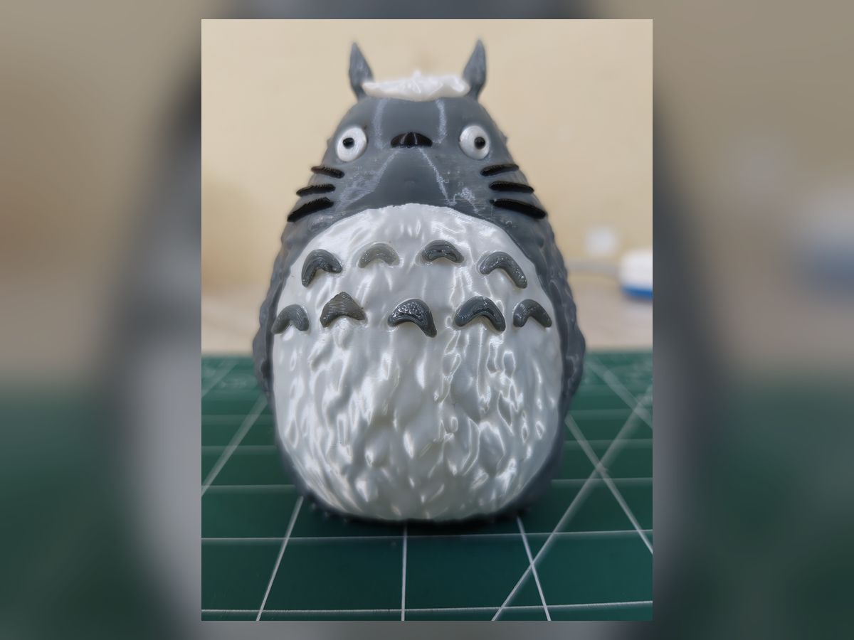 A hand-painted Totoro figurine on a cutting mat